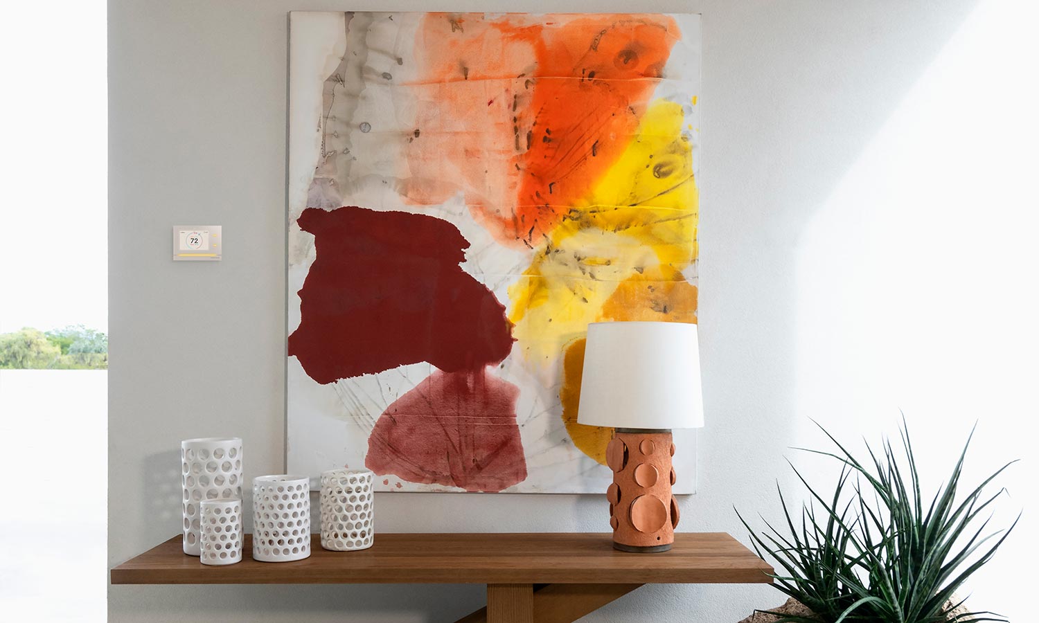 Crestron panel in a grey wall beside an abstract art piece