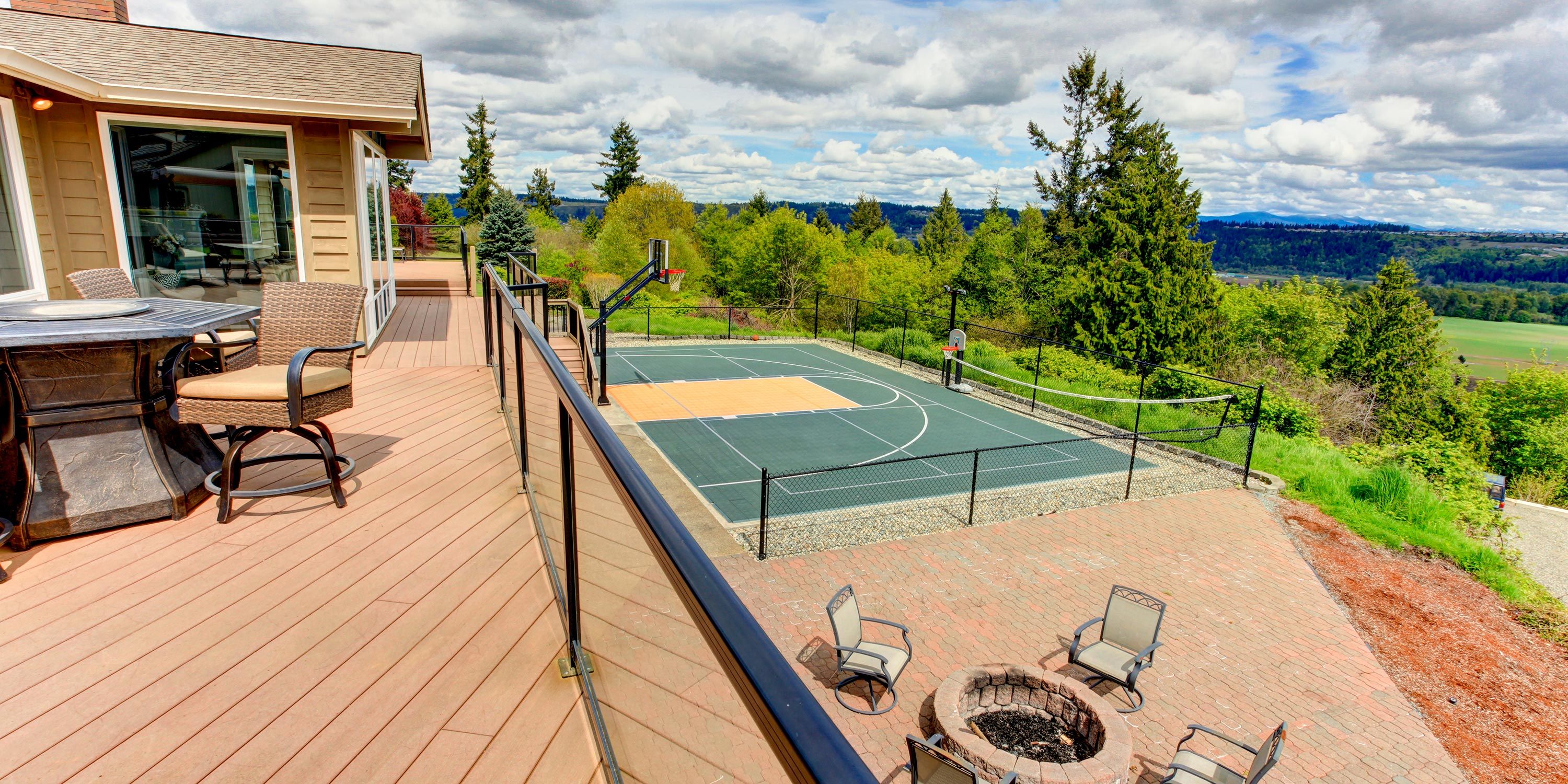Basketball court in the backyard of a wood colored house